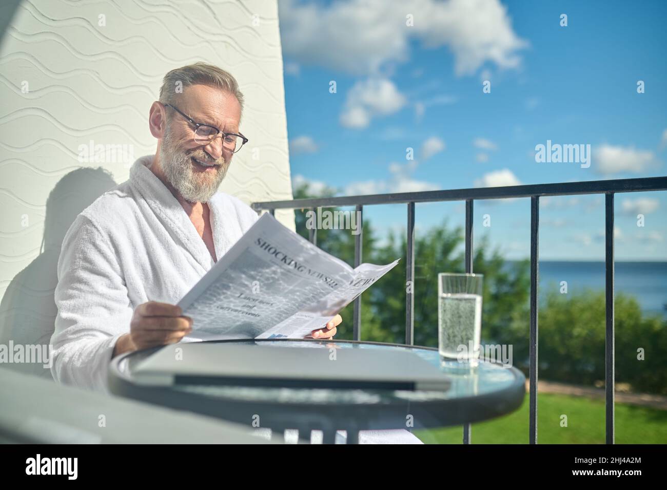 Pleased mature man reading good news in the newspaper Stock Photo - Alamy
