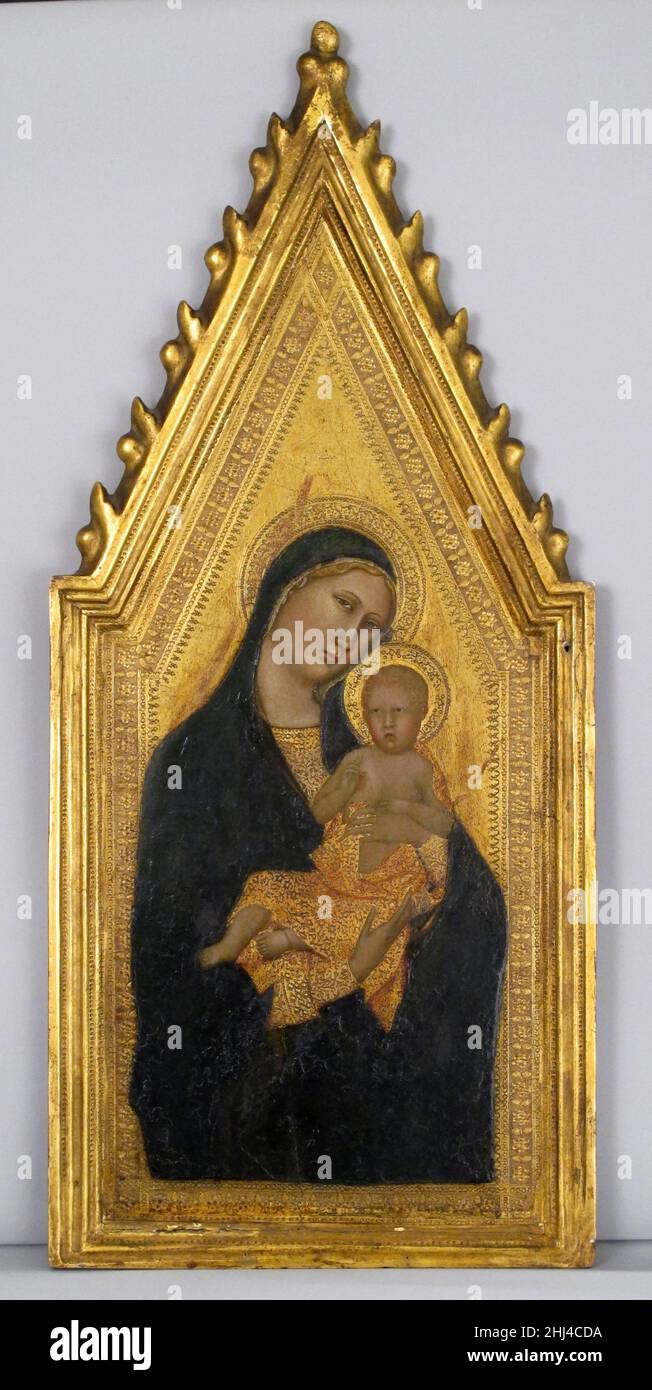 Tabernacle frame second quarter 14th century Italian, Siena The shallow molding profile of this engaged frame provides a gentle transition to the punched borders of the painting, a "Madonna and Child'" formerly attributed to Naddo Ceccarelli (fl. 1340s). The compressed ogee molding is refined with two lines of punching above and below it that echo the punched haloes and drapery of the Madona and Child. The summary acanthus leaves on the gabled outline of the frame are like a ripple of light surmounting the painting. In the nineteenth century this panel was attached to two rectangular panels al Stock Photo