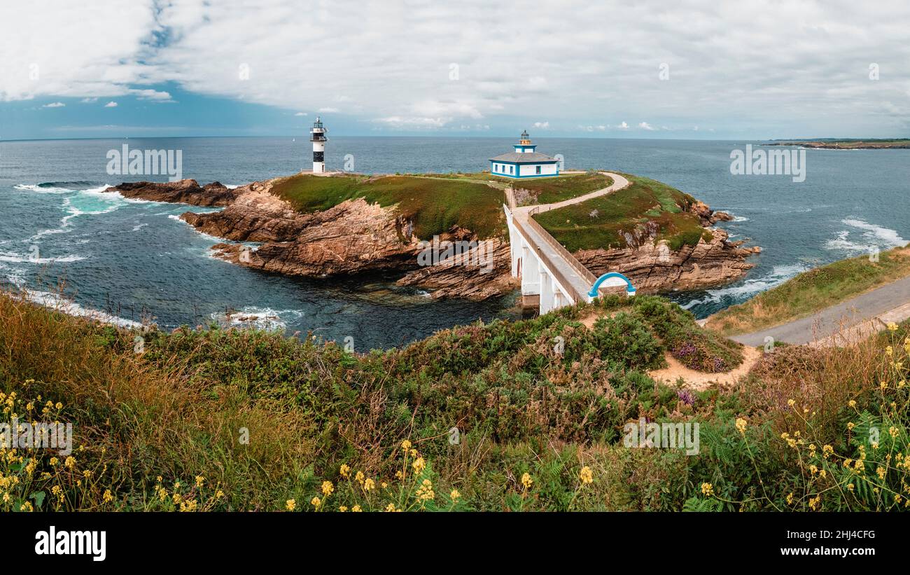 Lighthouse on a small rocky island off the coast connected to it by a ...