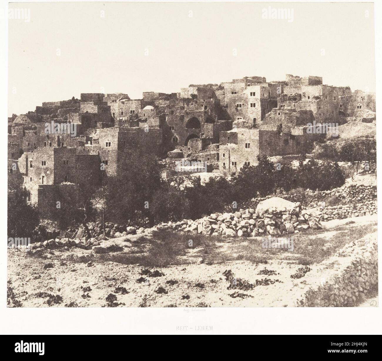 Jérusalem, Beit-Lehem, Vue générale 1854 Auguste Salzmann French Viewed from afar, the small, dark windows of Bethlehem’s geometric dwellings evoke the words of Salzmann’s countryman, the explorer François-René de Chateaubriand: 'This sacred land dares no longer express its joy, and locks within its bosom the recollections of its glory.' Other accounts, however, describe a bustling nineteenth-century city that received nearly as many visitors as the much larger Jerusalem. Ignoring the everyday life of Ottoman Palestine, Salzmann presented a vacant, closed land.. Jérusalem, Beit-Lehem, Vue géné Stock Photo