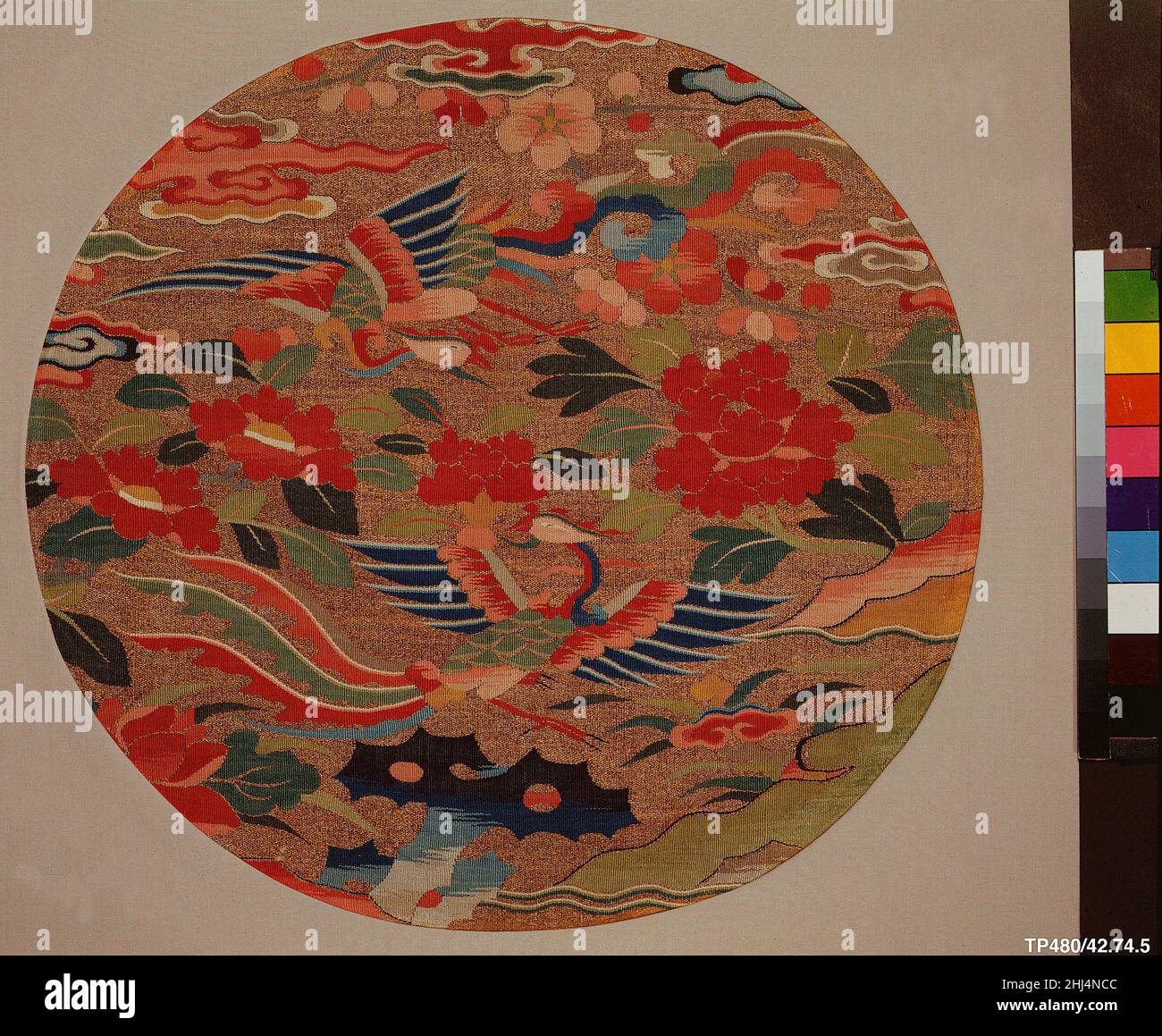 Circular textile with two phoenixes 16th�C17th century China This textile features a pair of phoenixes on a golden background among flowers of various seasons; clockwise from the lower left, they are lotus, camellia, prunus, tree peony, and auspicious fungus. The composition is anchored at the bottom by a garden rock.. Circular textile with two phoenixes  69209 Stock Photo