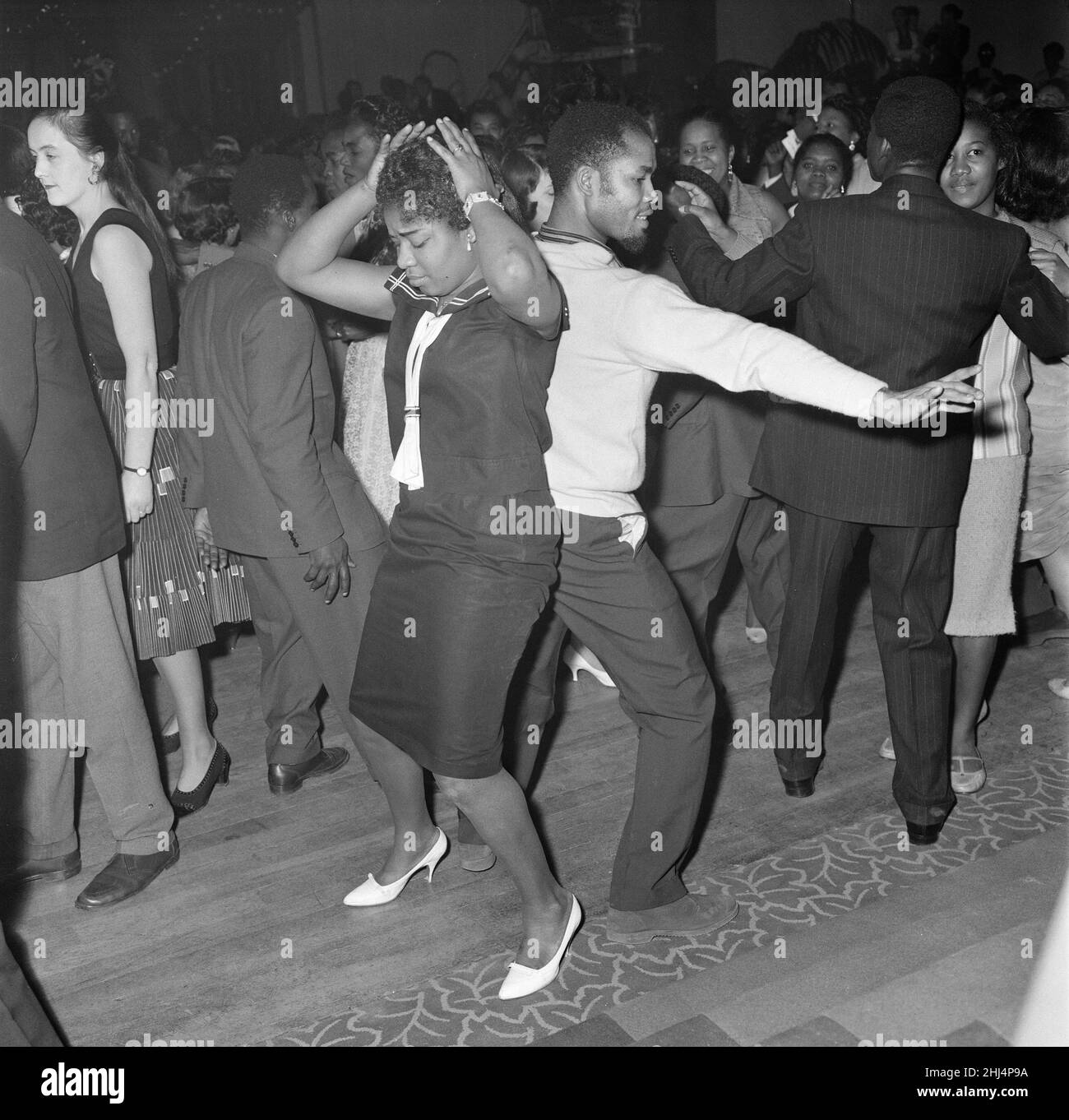 The first ever 'Notting Hill carnival', created in response to the previous year's racial riots in the area and the state of race relations at the time. The carnival, organised by Claudia Jones, was known as the Caribbean carnival or the West Indian Gazette Carnival and was held indoors at St. Pancras Town Hall. It would not be until 1964 that the carnival would move outside onto the streets of Notting Hill. Picture shows: Some of crowd who attended the event. 30th January 1959. Stock Photo