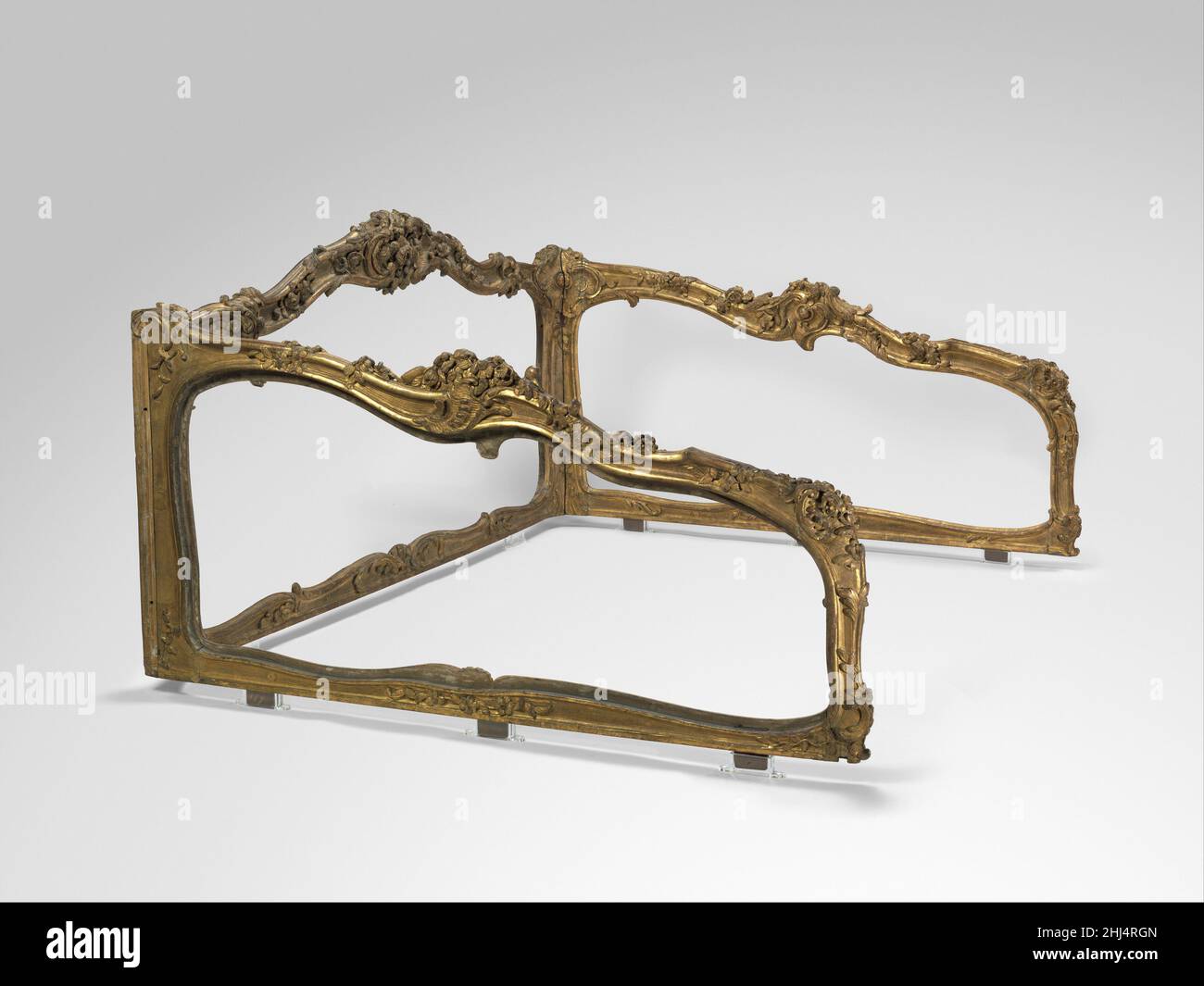 Frame for a daybed (Lit de repos) ca. 1740-45 French This elaborately carved three-part frame was originally part of a daybed or a sofa. Although not signed, the curving outline of the frame is enriched with heart-shaped cartouches, rocaille motifs and floral ornament that bear resemblance to the work of the menuisiers or joiners Jean-Baptiste Tilliard and Nicolas-Quinibert Foliot. Normally invisible, the rectangular blocks underneath the frame are the tenons which would have fitted in similar size openings, the mortises, to join the frame to the lower part of the bed or sofa. Although incompl Stock Photo