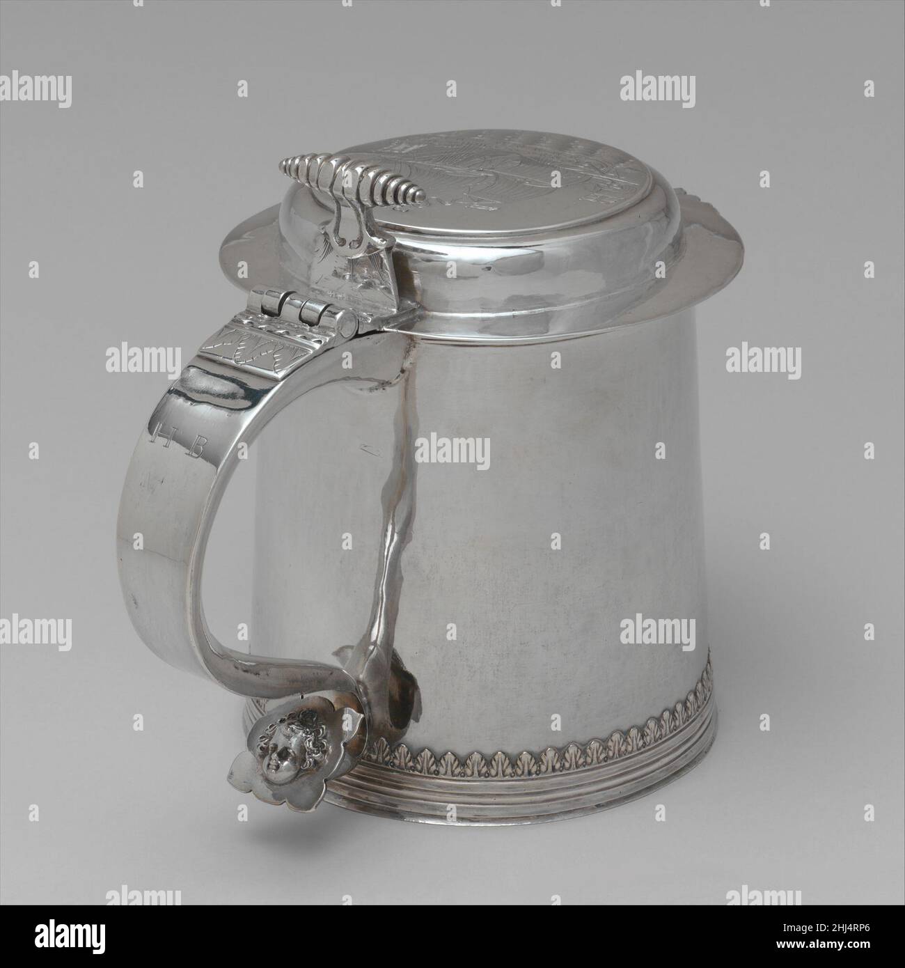 Tankard 1700–1710 Gerrit Onckelbag In 1698, Giles Shelley (1664–1710), a New York City merchant and sea captain, sailed in command of the ship Nassau for Madagascar, a favorite haunt of Captain Kidd and his pirates. Shelley returned to New York with a vast amount of treasure but, suspected of complicity with Kidd, he was arrested on a charge of piracy. He was later released and lived for many years, a wealthy and respected merchant. This tankard was probably presented to Shelley by the merchants who financed his enterprise. The handsomely engraved coat of arms is that of the Shelley family, an Stock Photo