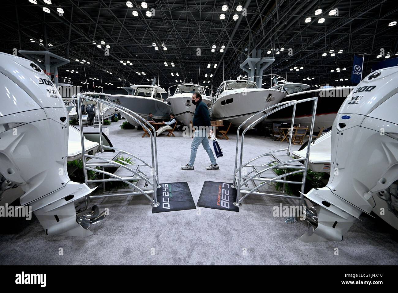 A visitor walks past Pursuit Boats display while attending the 2022 New