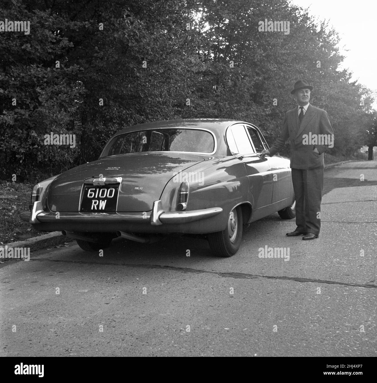 Daily Herald motor racing correspondent Thomas H Wisdom standing beside a new Jaguar Mark X.  11th October 1961. Stock Photo