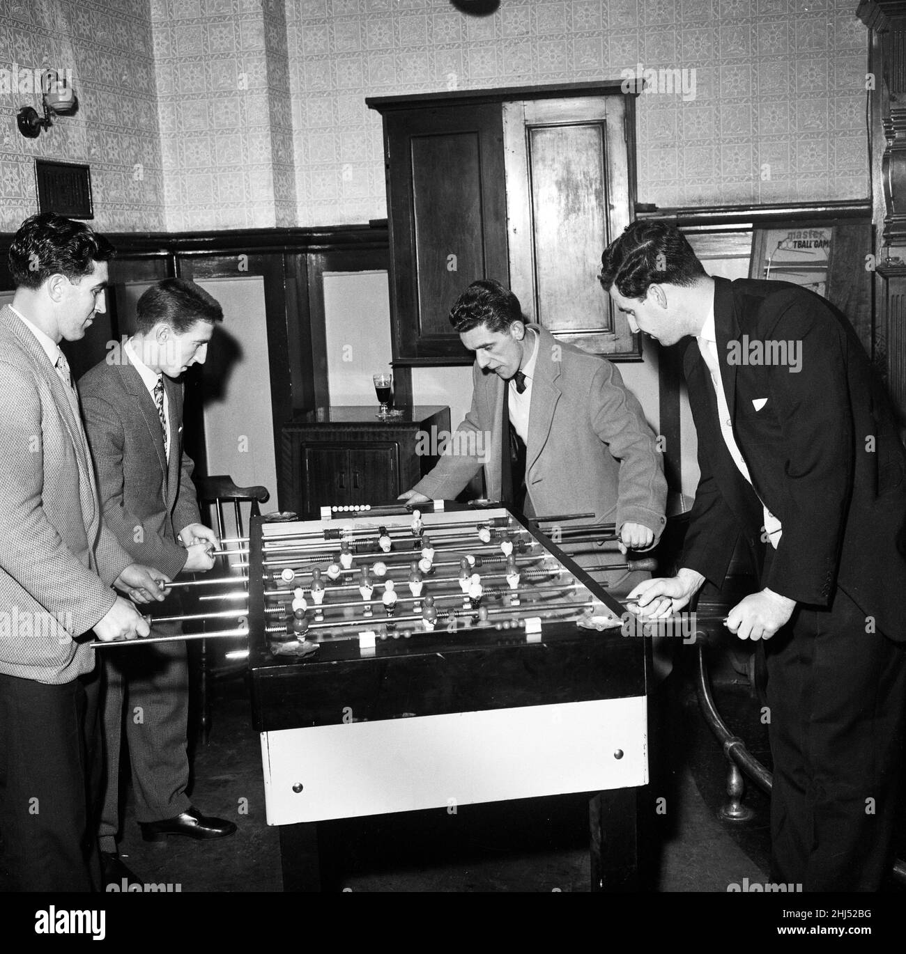 Tottenham Hotspur footballers enjoy a game of table football during a lunch time visit to a local pub after a training session.Players are Bobby Smith and Cliff Jones (top) forming the team on the left, playing against  Tommy Harmer and Maurice Norman (right). 14th March 1960. Stock Photo