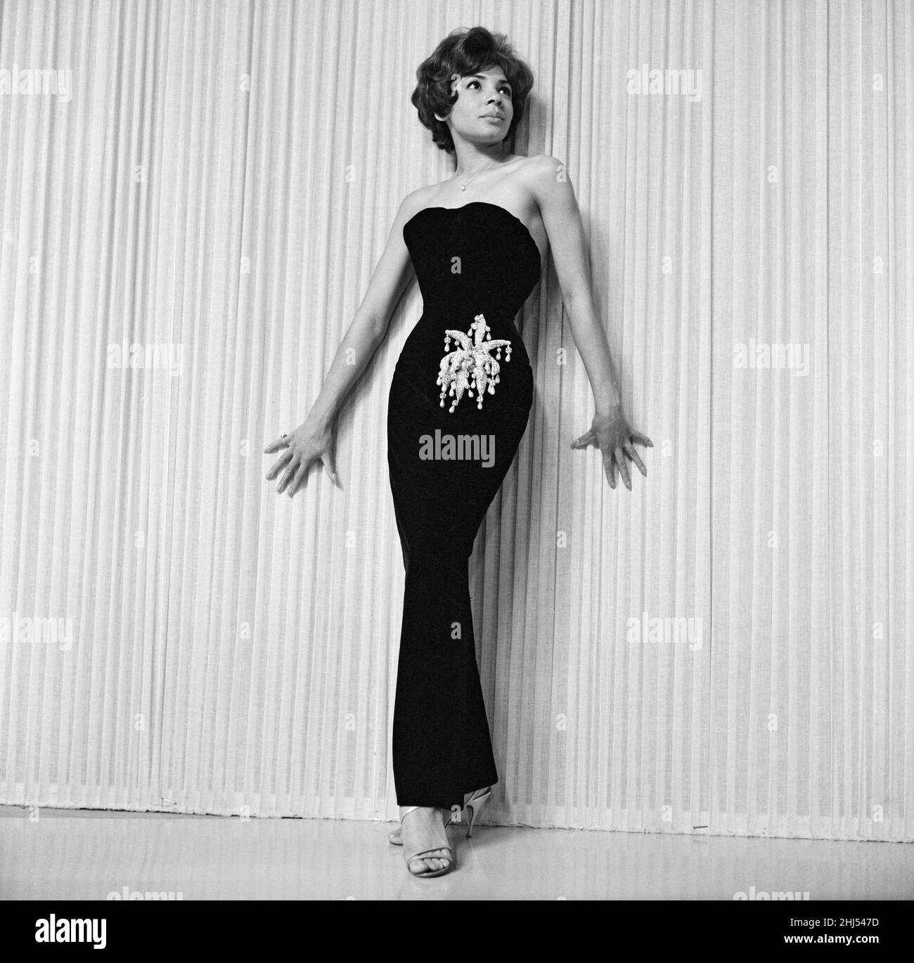 Shirley Bassey wearing the hip-hugging black velvet dress that she says catches mens' eye. She was photographed at Wood Green Television Studios where she was rehearsing. 17th June 1960. Stock Photo