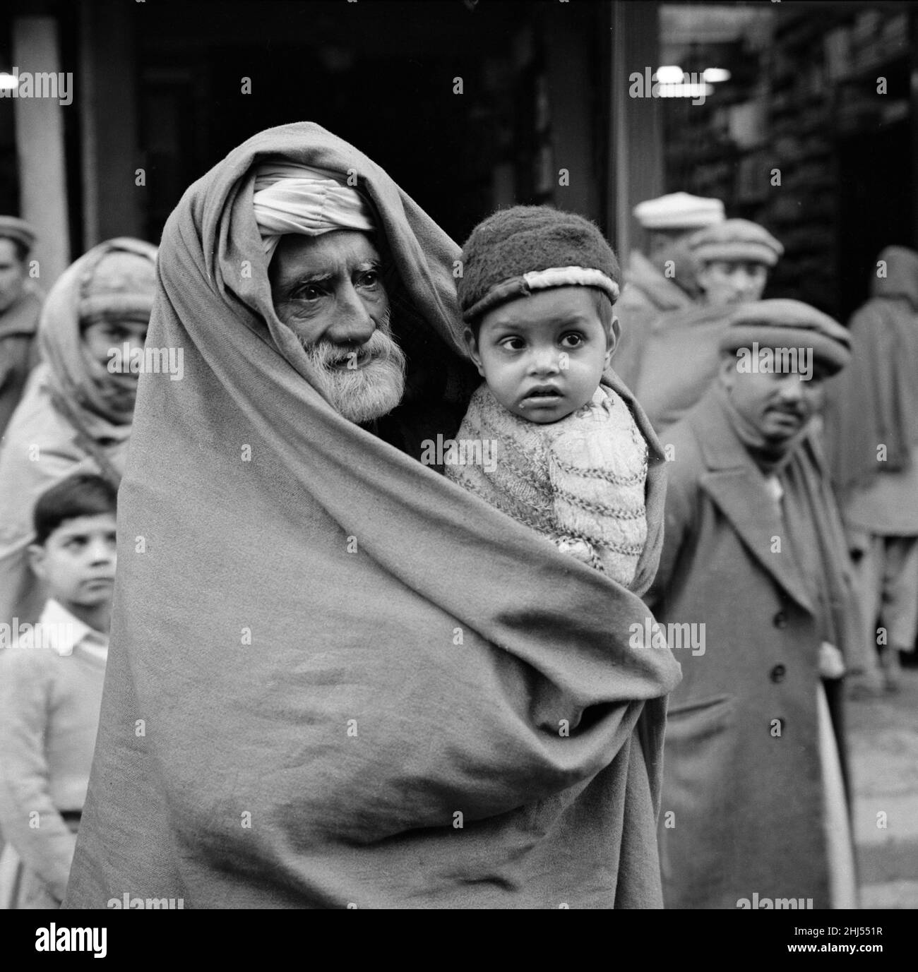 A grandfather and his grandson seen here on the streets of Peshawar the capital of the North West Frontier province of Pakistan. February 1961  l Stock Photo