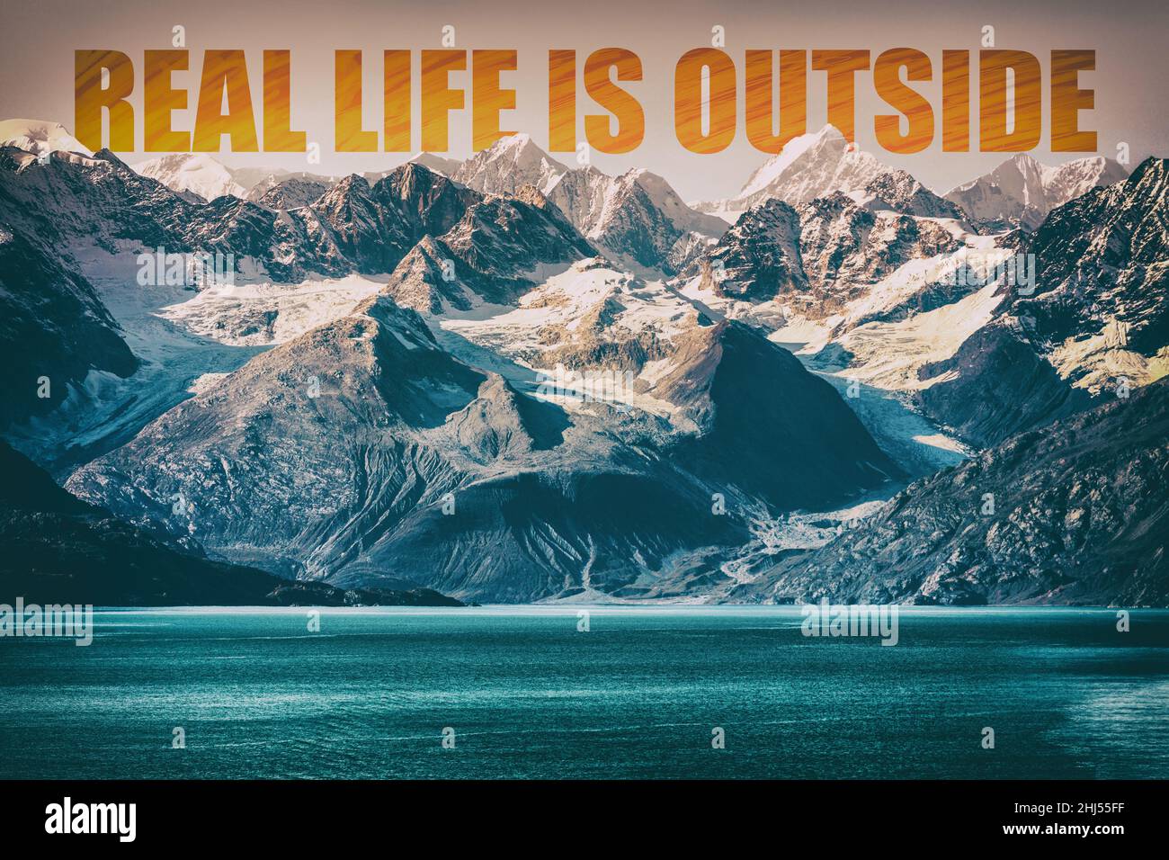 REAL LIFE IS OUTSIDE motivational quote on mountain range landscape background. Adventure message to inspire people to travel in nature. Snow capped Stock Photo