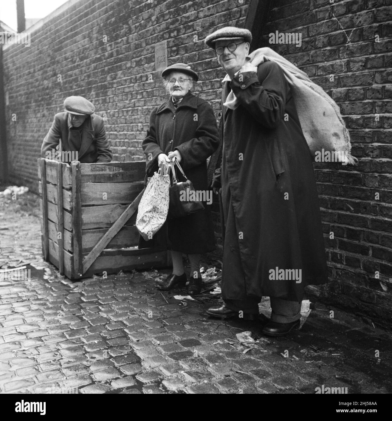 OAP's collecting firewood outside a furniture factory in Denmark Hill, London. 18th December 1960. Stock Photo