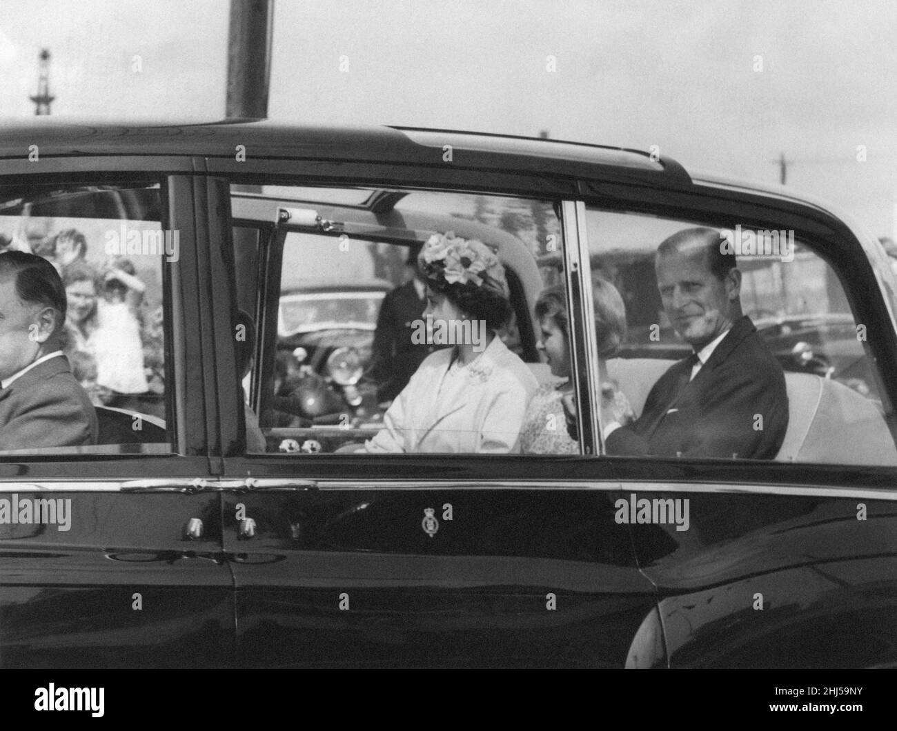 Queen Elizabeth II pictured during two day visit to the welsh capital, Cardiff, Wales, Saturday 6th August 1960. Out Picture Shows ... The Queen, Duke of Edinburgh, Princess Anne and Prince Charles (unseen) smile out at the crowds in the afternoon sunshine as they drive to the National Eisteddfod of Wales, a cultural festival of music, song and poetry. Stock Photo