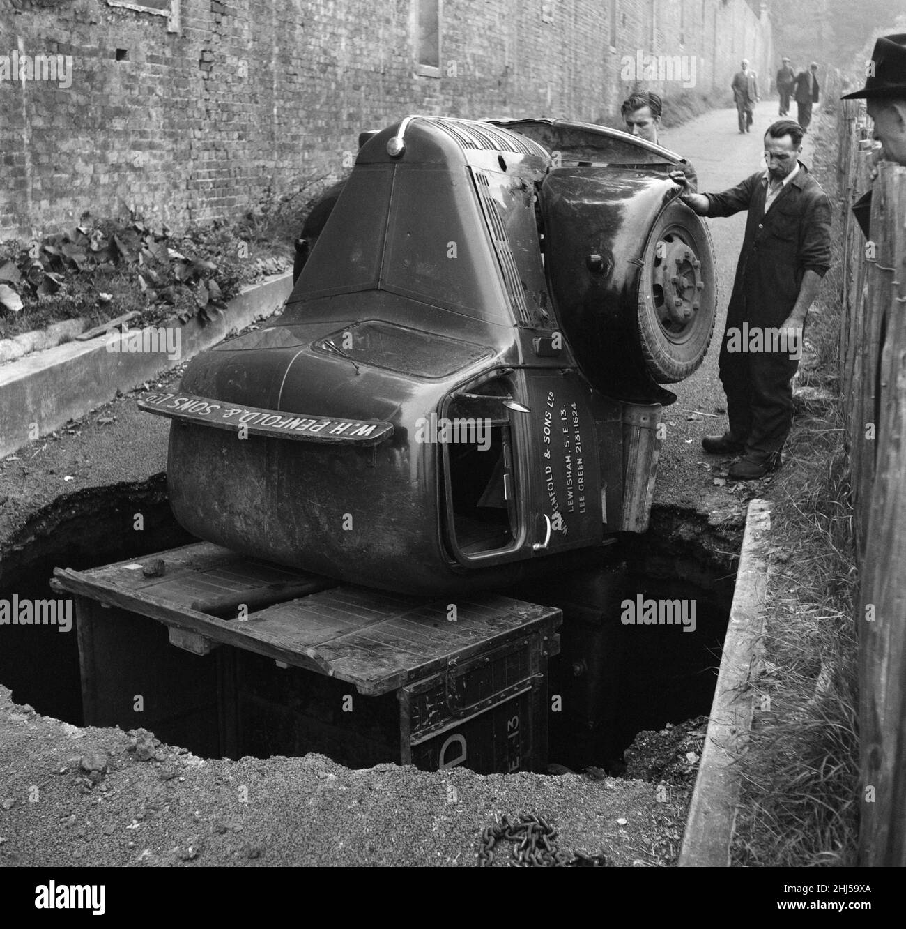 As Frank Mercer was driving his 3 ton lorry near the Crystal Palace part of the road caved in. The lorry, pictured, took a backward dive into the hole. Frank, was treated in hospital for shock. 8th October 1957. Stock Photo
