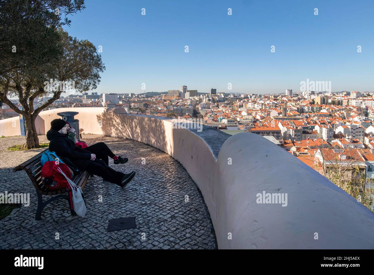 Lisbon, Portugal. 21st Jan, 2022. People look out over the city from the Penha de Franca viewpoint. According to the global numbers of the pandemic since March 2020, according to the General Health Direction (DGS), when the first patient was reported in Portugal, there have been 2,377,818 confirmed cases, 1,842,153 recovered cases and 19,703 fatalities due to COVID-19. (Credit Image: © Jorge Castellanos/SOPA Images via ZUMA Press Wire) Stock Photo