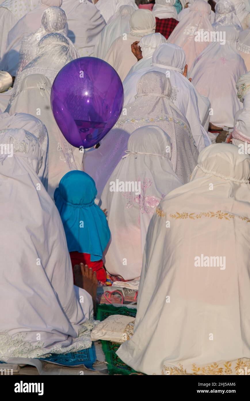 Women and child with balloon wearing hijab muslim dress, Idul Fitri ceremony, Denpasar, Bali, Indonesia Stock Photo
