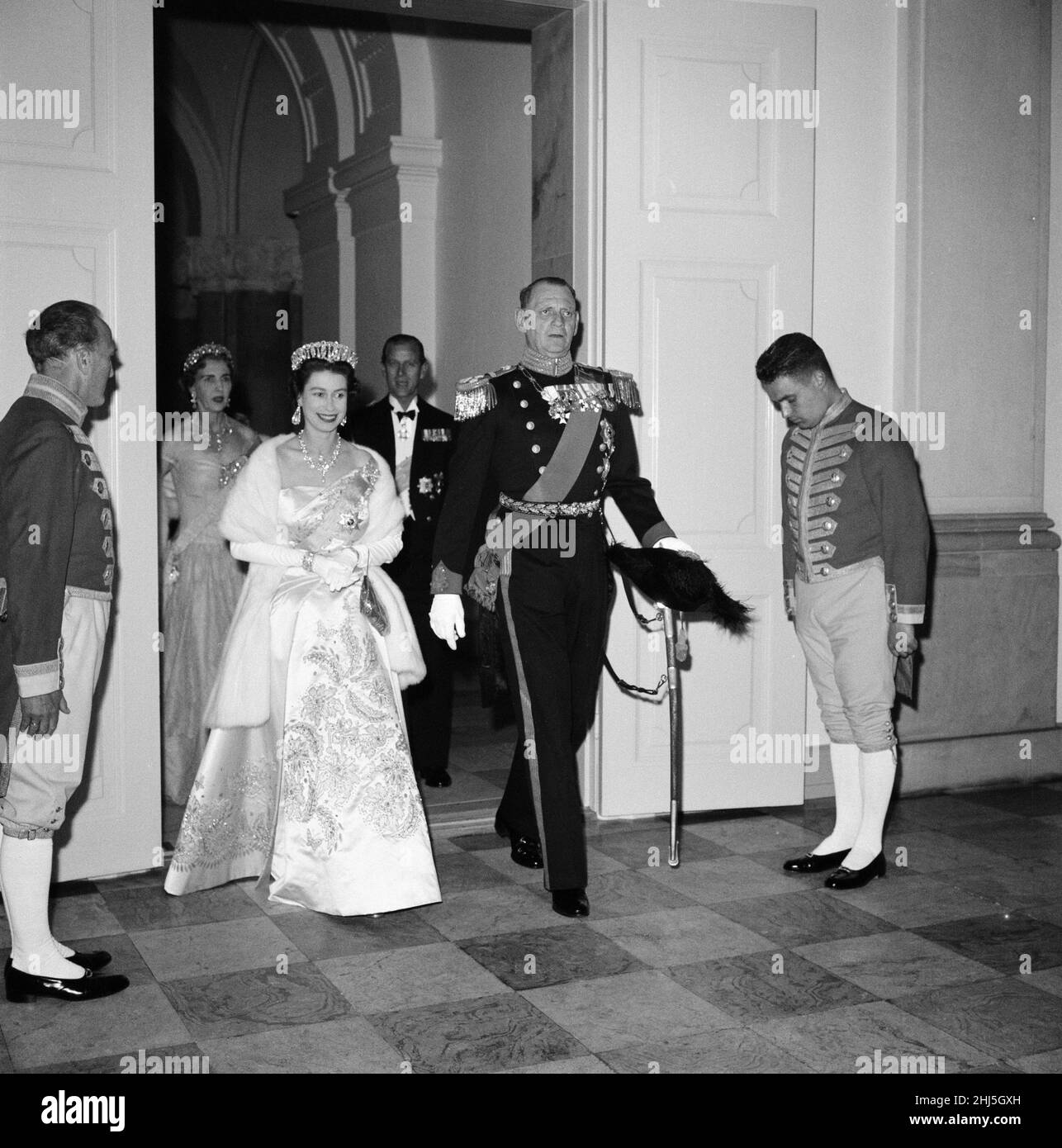 Queen Elizabeth II and Prince Philip, Duke of Edinburgh visit to Denmark. Pictured, Queen Elizabeth and King Frederik IX of Denmark at Christiansborg Palace arriving for a state banquet. Behind them are Queen Ingrid of Denmark and Prince Philip. Queen Elizabeth's fabulous Norman Hartnell gown is made of pale pink satin and trimmed with a gleaming jewelled pattern. Over her shoulder she wears the blue sash of the Danish Order of the elephant. 21st May 1957. Stock Photo