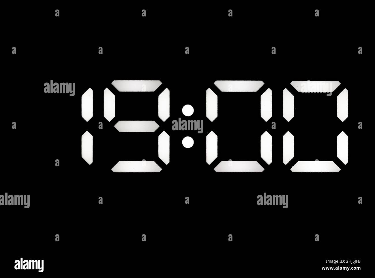 Real white led digital clock on a black background showing time 19:00