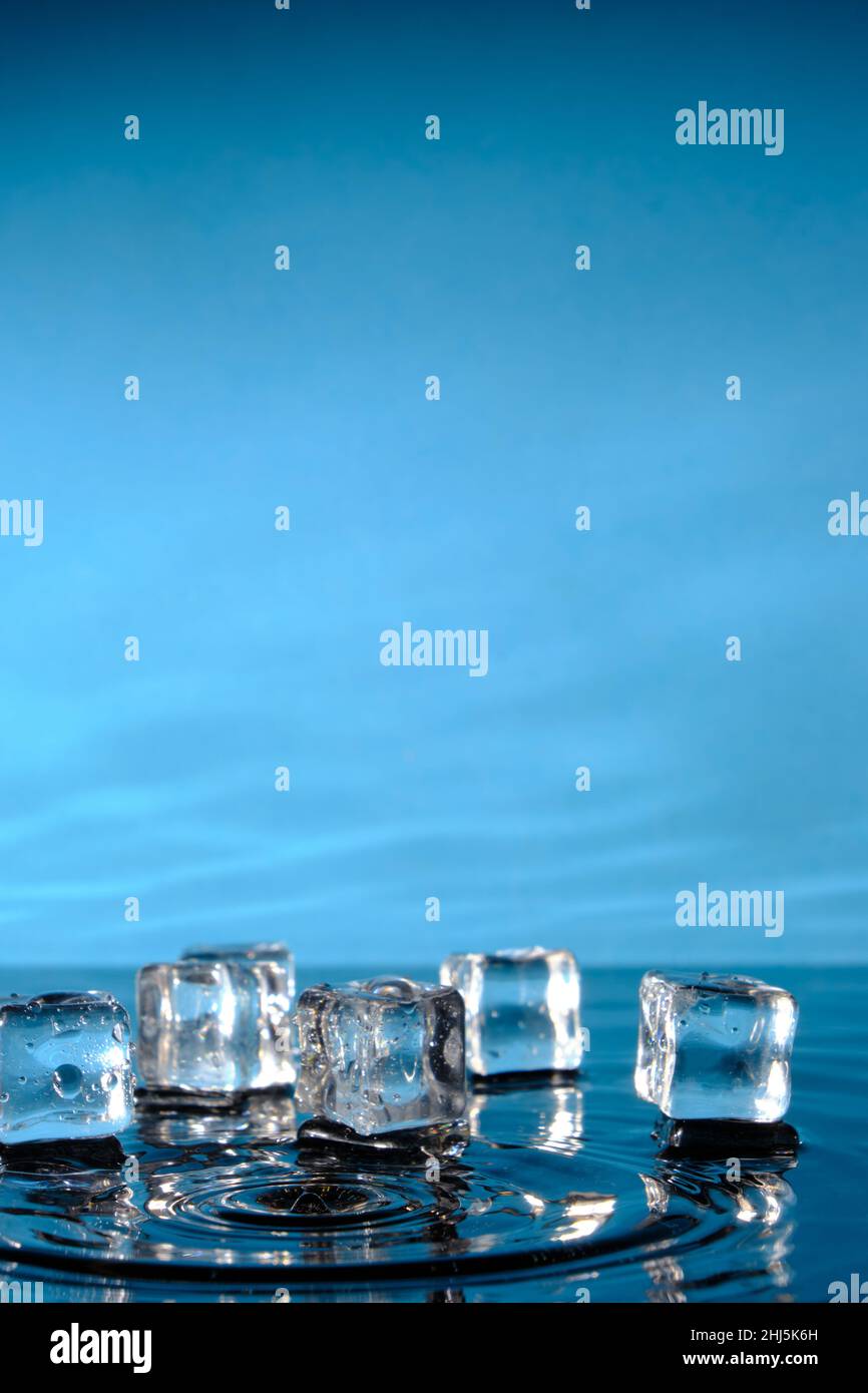 Ice cubes in bright blue water and a splash of raindrops Stock Photo ...