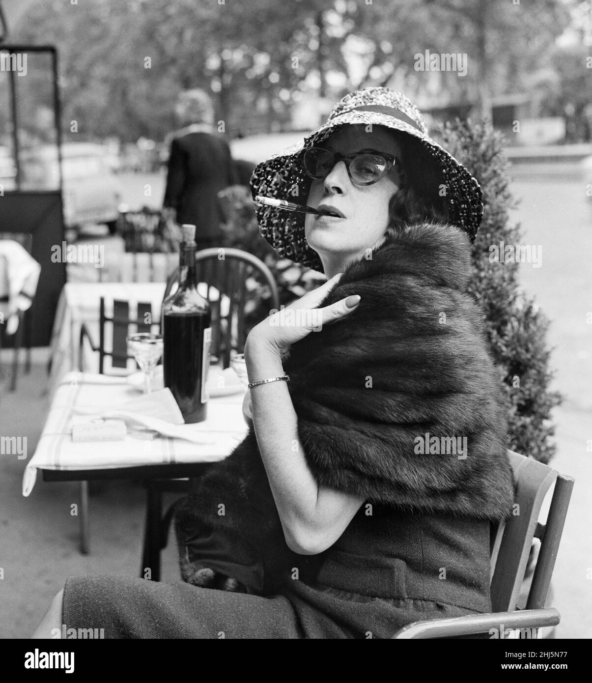 Daily Mirror agony aunt Marjorie Proops sitting at a cafe in Paris, wearing a hat and smoking a cigarette.  May 1960. Stock Photo