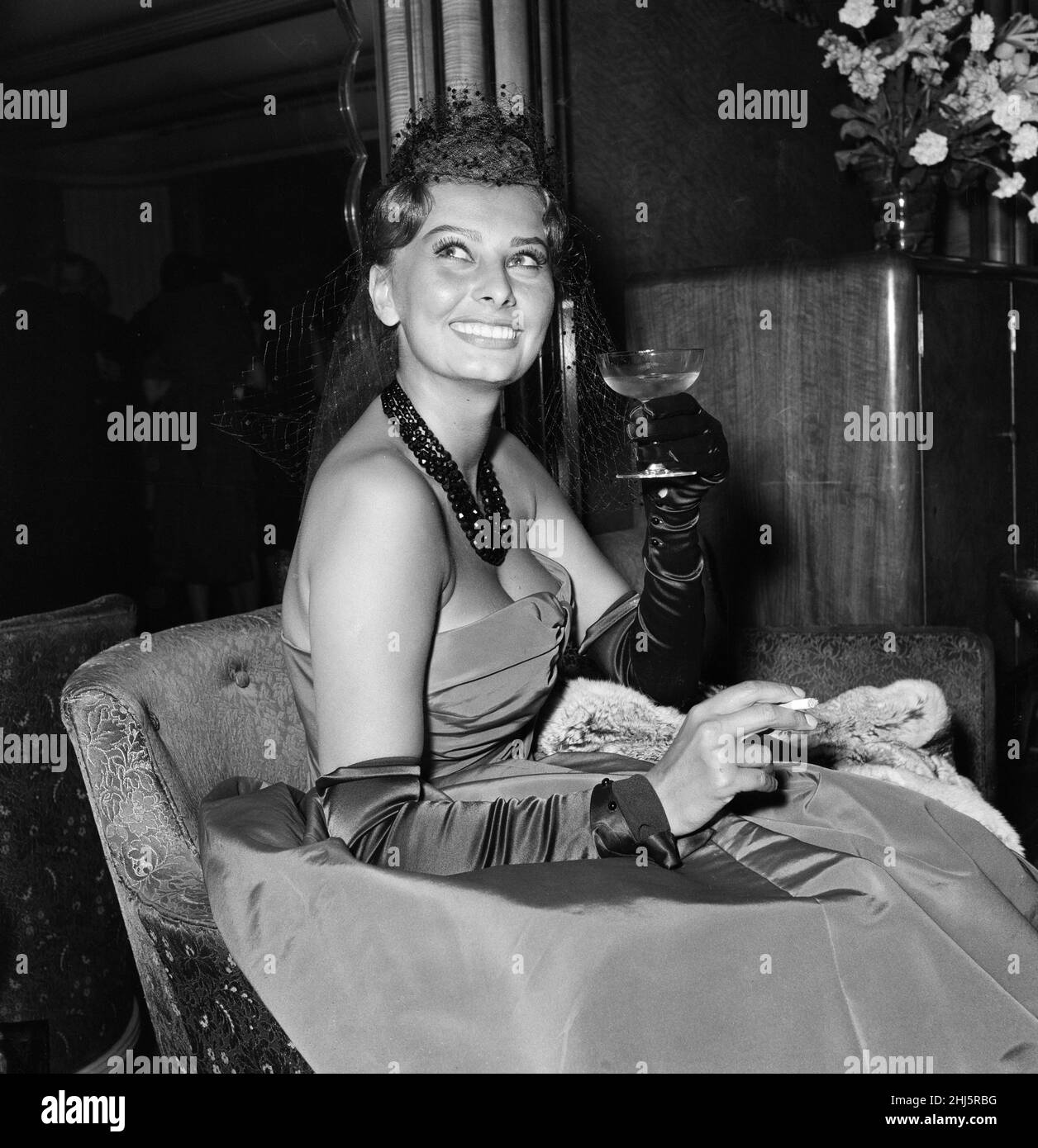 Variety Club charity premier of 'The Key', Odeon Leicester Square, London. The Key is a 1958 British war film set in 1941 during the Battle of the Atlantic. Pictured, Sophia Loren, one of the stars of the film, with a glass of champagne. 29th May 1958. Stock Photo