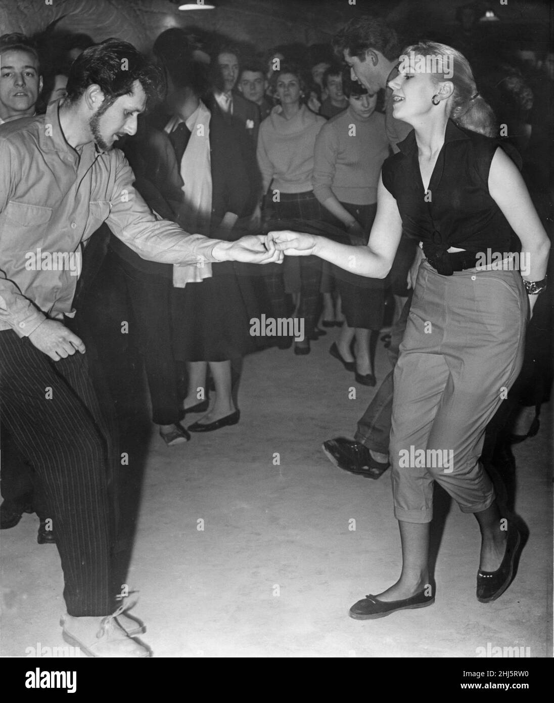 A couple dance the jive on the opening night of The Cavern Club in Liverpool, 15th January 1957. The Cavern Club is a nightclub at 10 Mathew Street, in Liverpool, England.  The original Cavern Club opened on Wednesday, 16 January 1957 as a jazz club, later becoming a centre of the rock and roll scene in Liverpool in the 1960s. The Beatles played in the club in their early years.  The original Cavern club closed in March 1973 and was filled in during construction work on the Merseyrail underground rail loop. Focus were the last band to play the original Cavern a few days before the club was shu Stock Photo