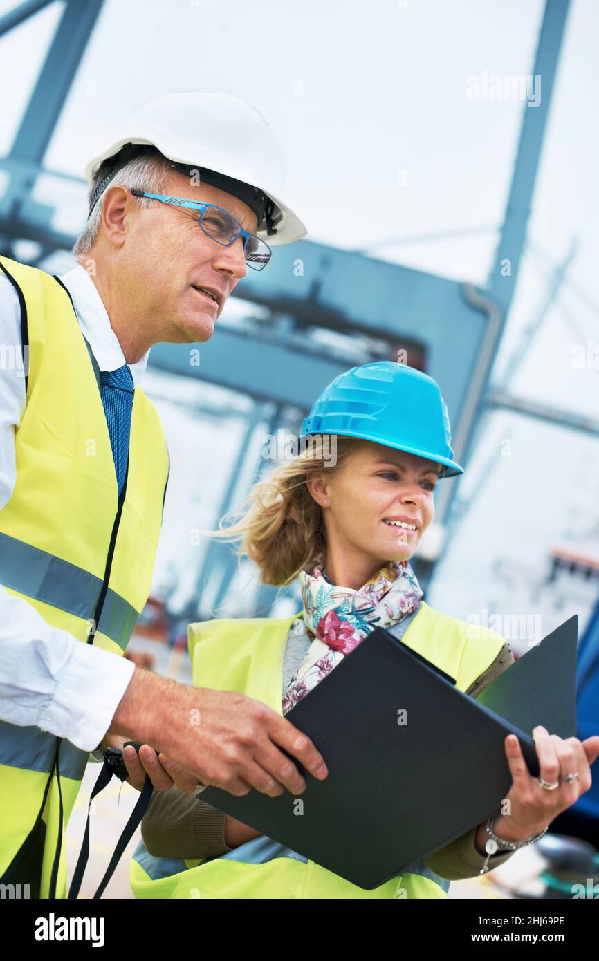 Slight confusion. Two engineers discussing planning on a site while looking away. Stock Photo