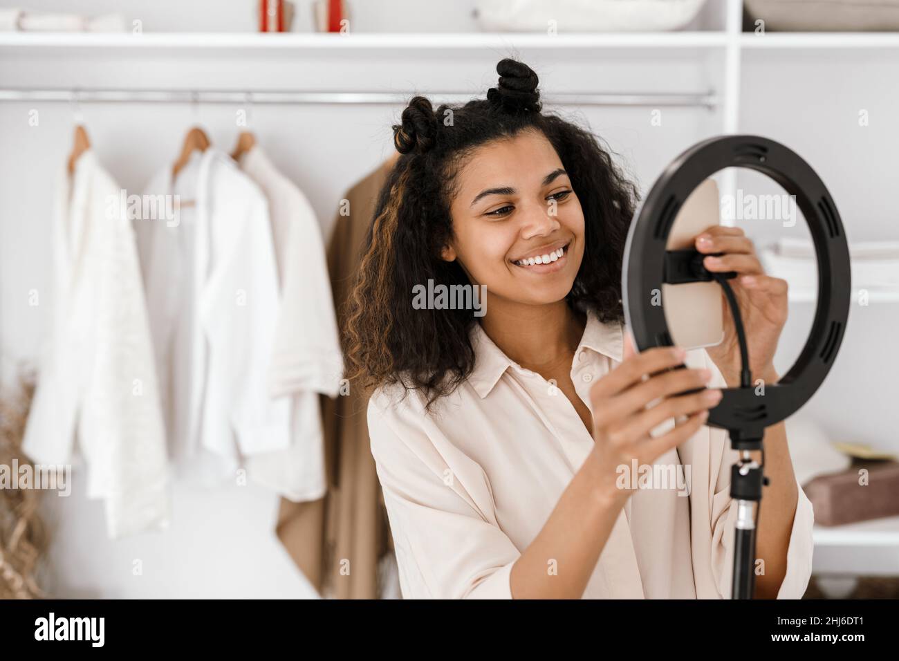 Black young woman smiling while taking selfie footage on cellphone at ...