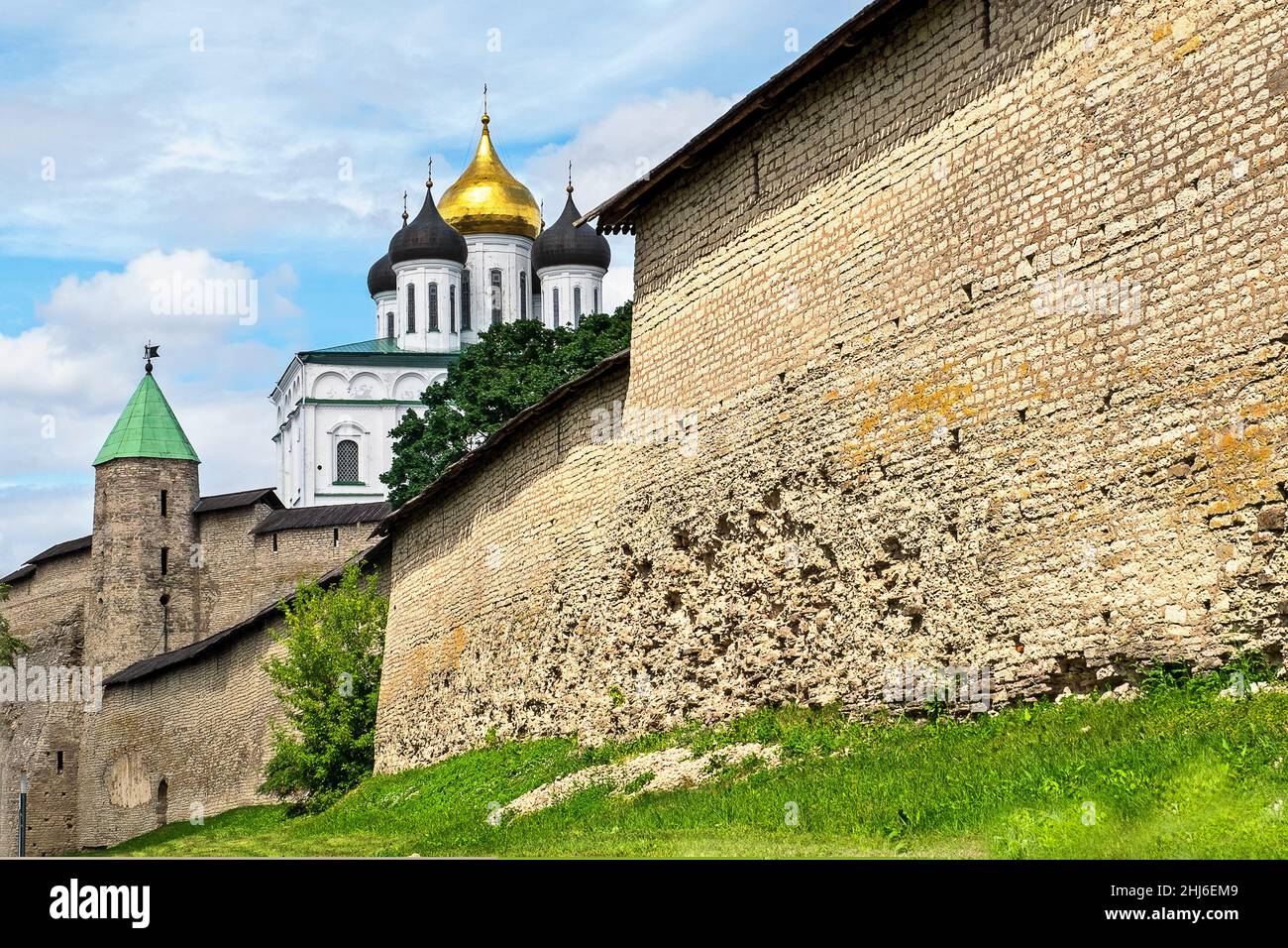 Pskov, Pskov region, Russia. - July 20, 2021. View of ancient wall of medieval fortress Kremlin and dome of Orthodox Holy Trinity Cathedral. Selective Stock Photo