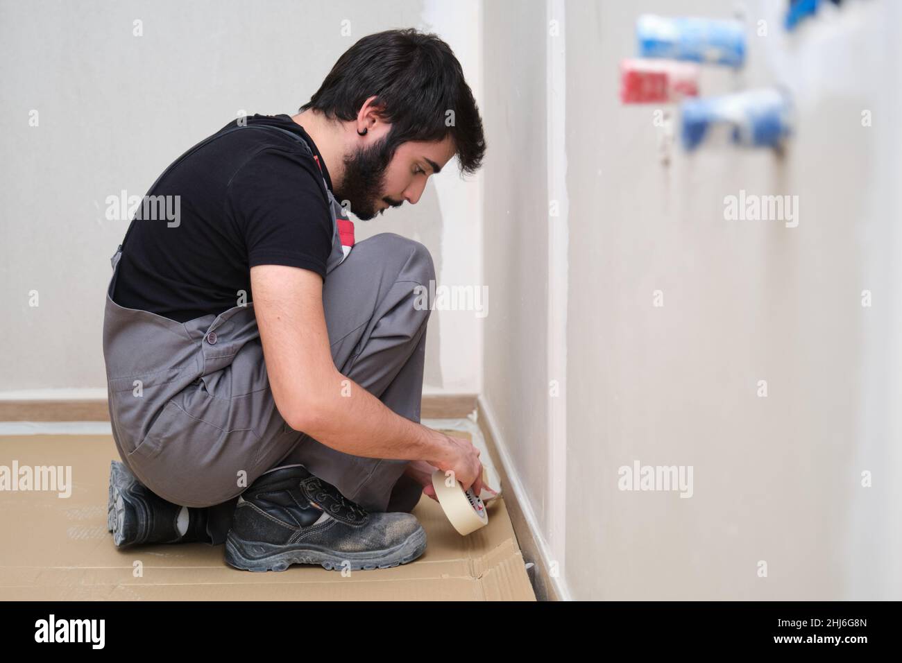 Professional painter using tape to cover the floor before