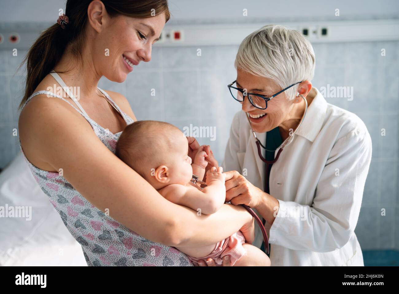 Mother holding baby for pediatrician doctor to examine Stock Photo - Alamy