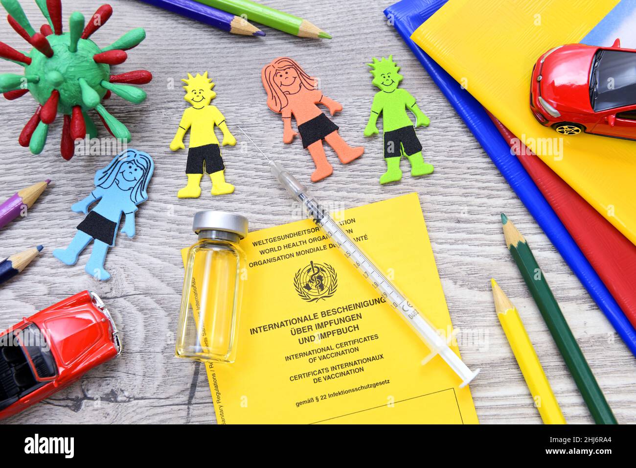 Impfpass, Impfspritze, Impfstoff und Kinderfiguren, Symbolfoto Covid-Impfung für Kinder Stock Photo