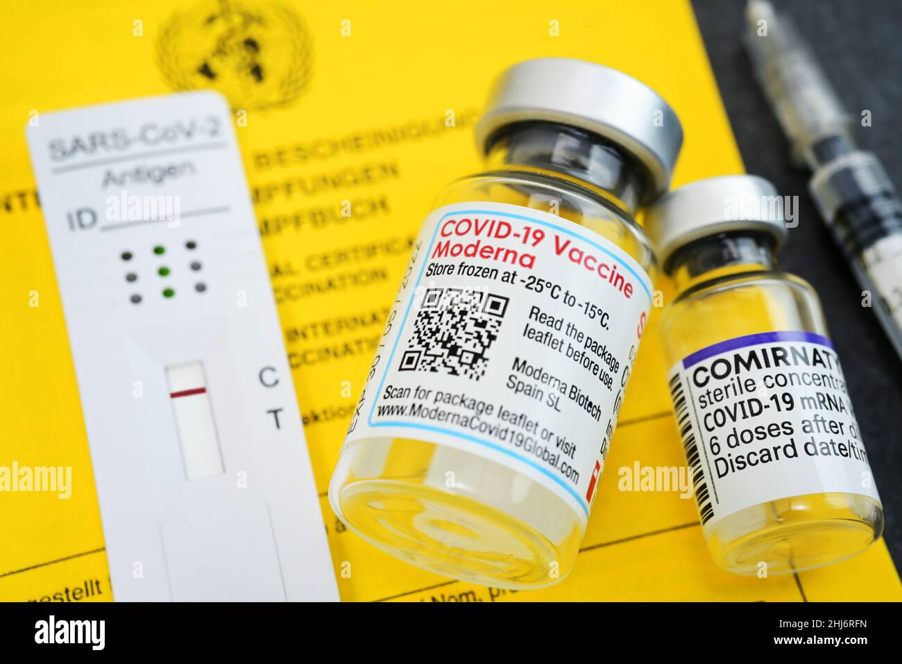 Impfausweis mit Impfspritze, negativem Corona-Schnelltest und Impfstofffläschchen von Biontech und Moderna Stock Photo