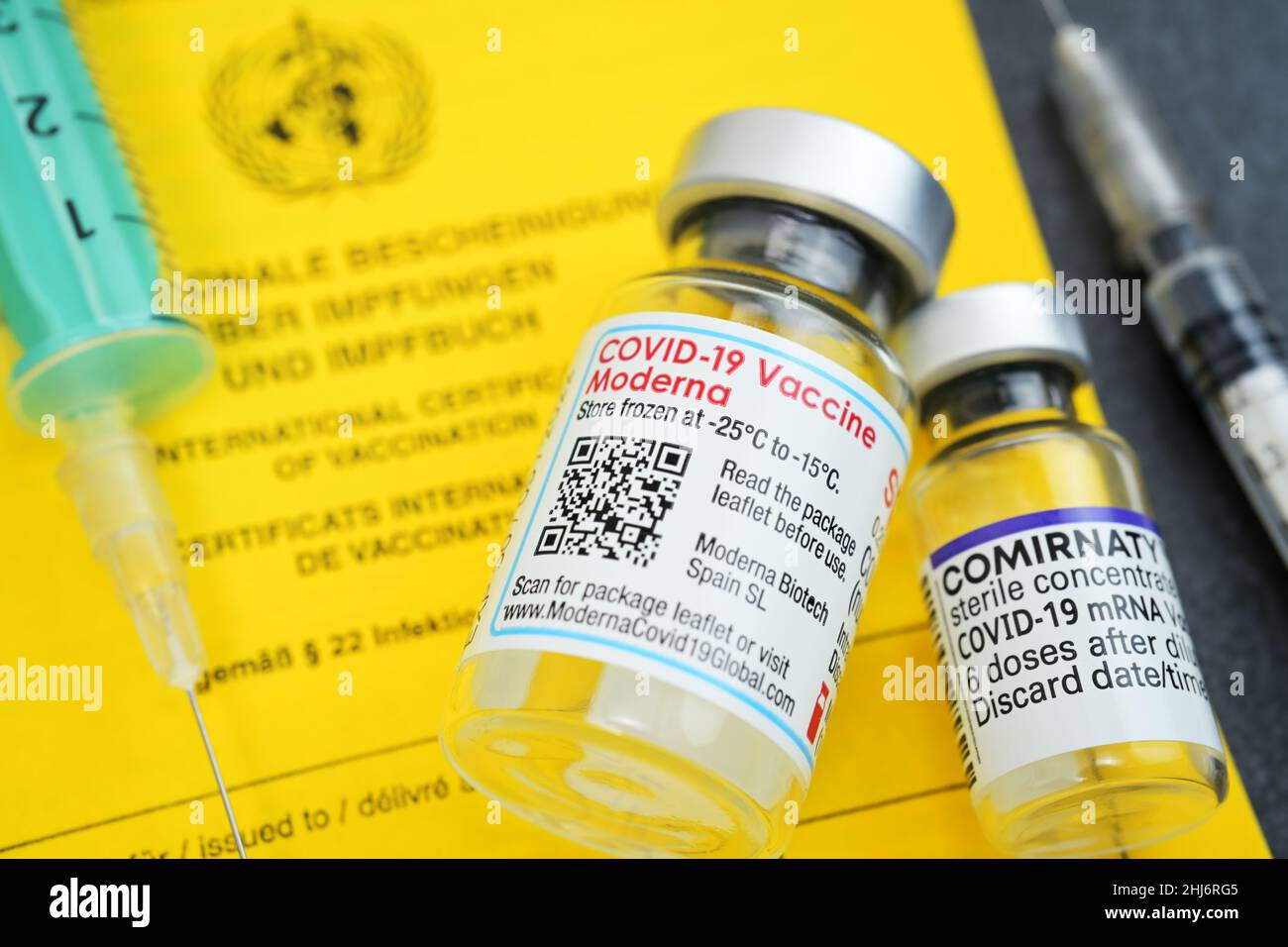 Impfausweis mit Impfspritzen und Impfstofffläschchen von Biontech und Moderna Stock Photo