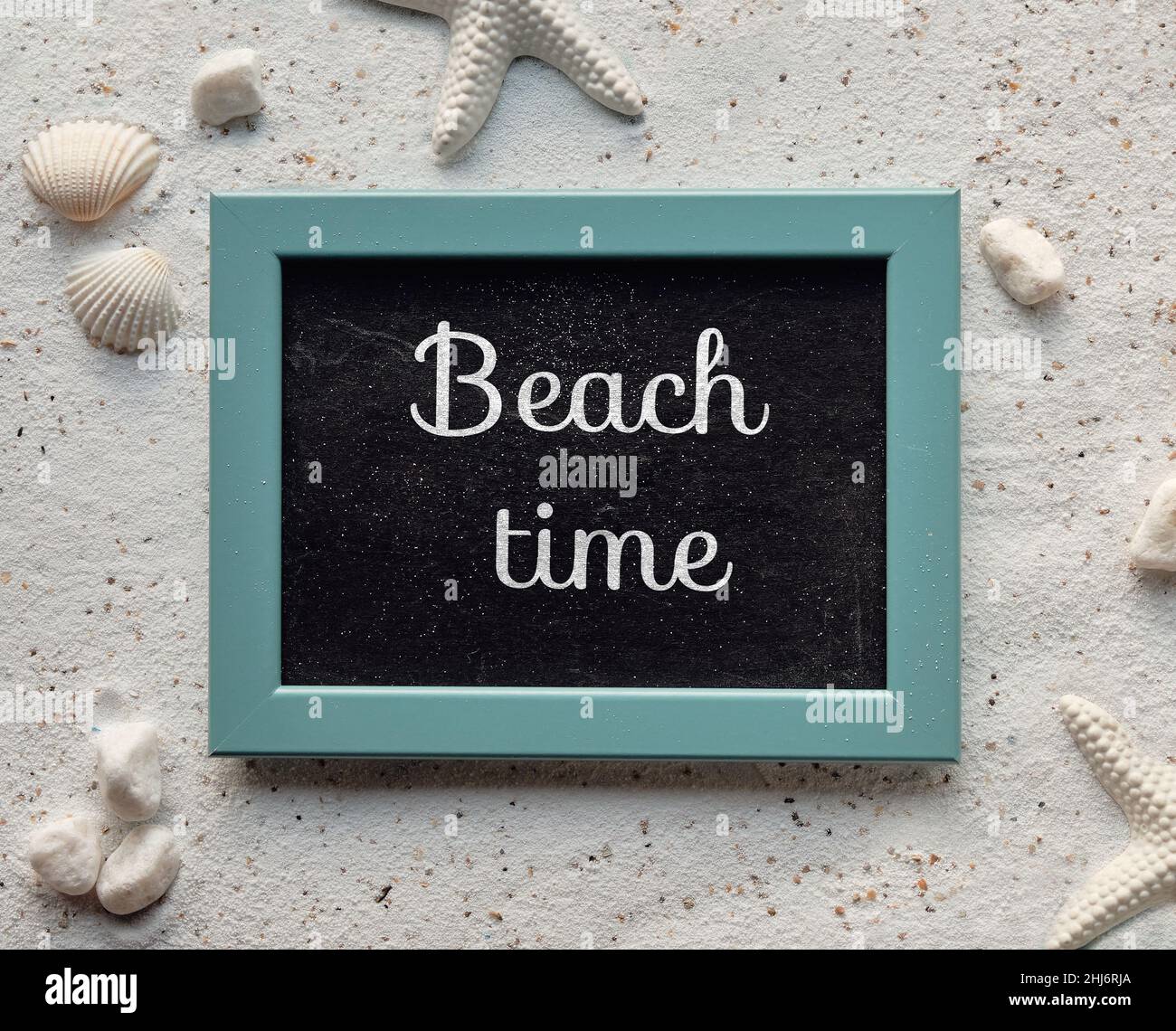 Beach time text on blackboard in mint green frame. Background with white sand with shells, starfish, Stock Photo