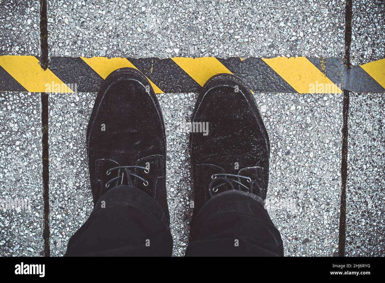 Schuhe vor einer Corona-Abstands-Markierung auf dem Boden Stock Photo