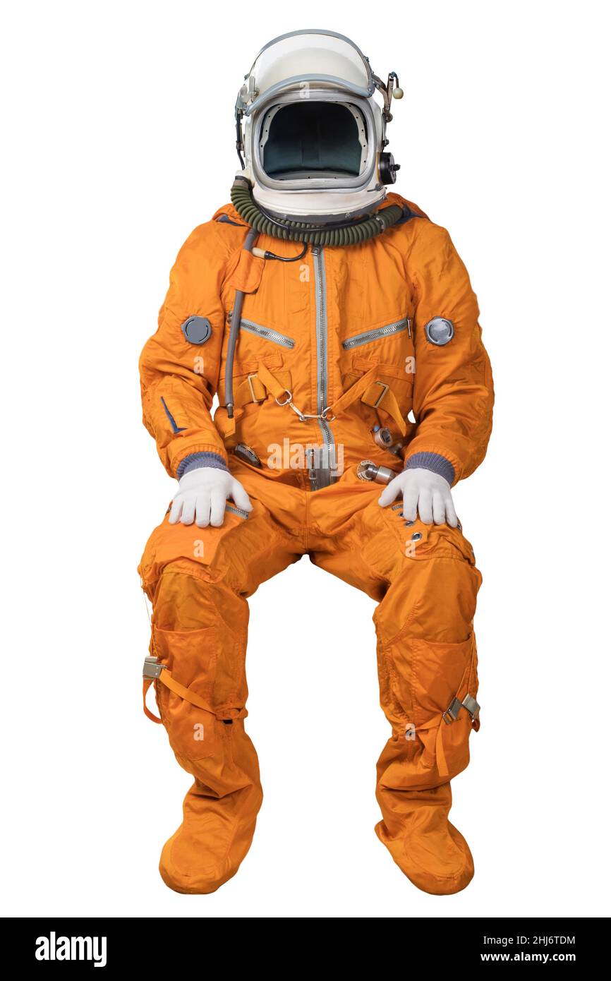 Astronaut wearing an orange spacesuit and open space helmet sitting isolated on white background Stock Photo