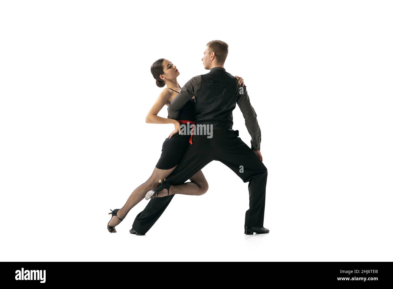 Beautiful sportive young man and woman dancing Argentine tango isolated