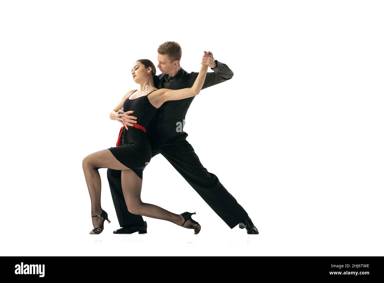 Beautiful sportive young man and woman dancing Argentine tango isolated