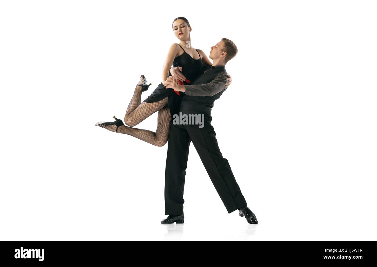 Beautiful sportive young man and woman dancing Argentine tango isolated