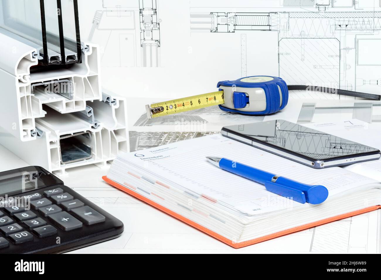 Work space table with notepad, pen, tape measure, calculator, sample of triple glazed and pvc