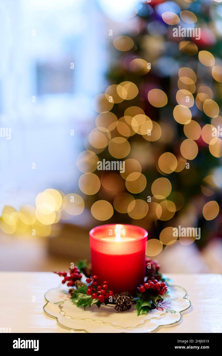 Lit Candle in front of Christmas Tree Stock Photo