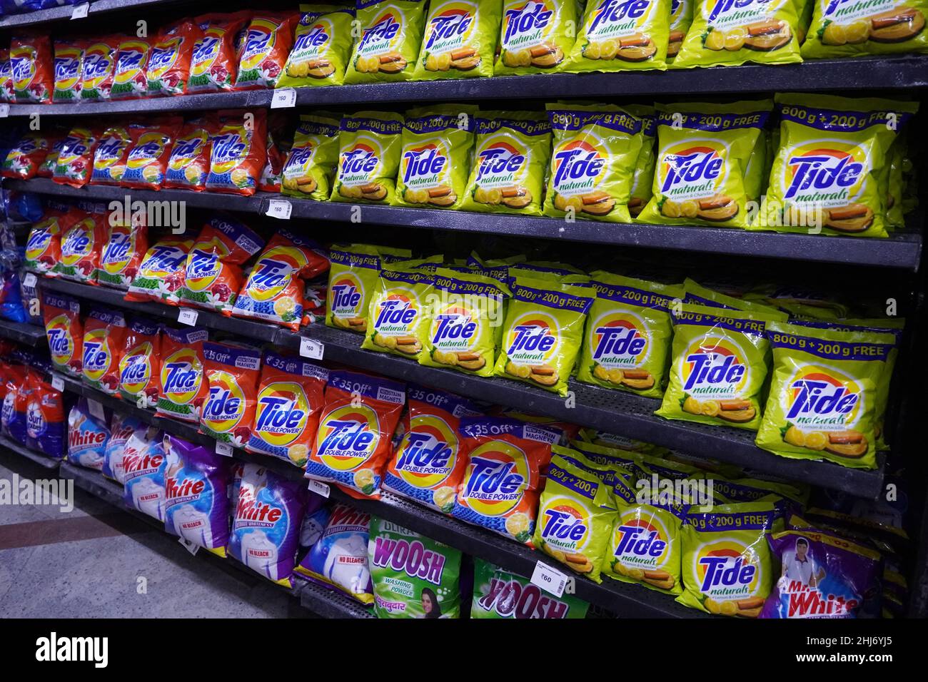 Different types of detergents on shelves in a supermarket. Tide is a