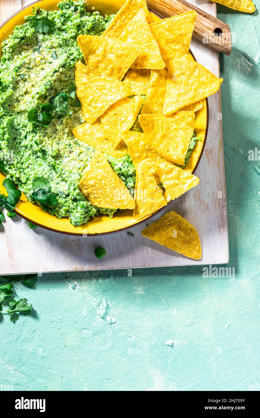 Nachos with green peas guacamole. Healthy vegetarian avocado
