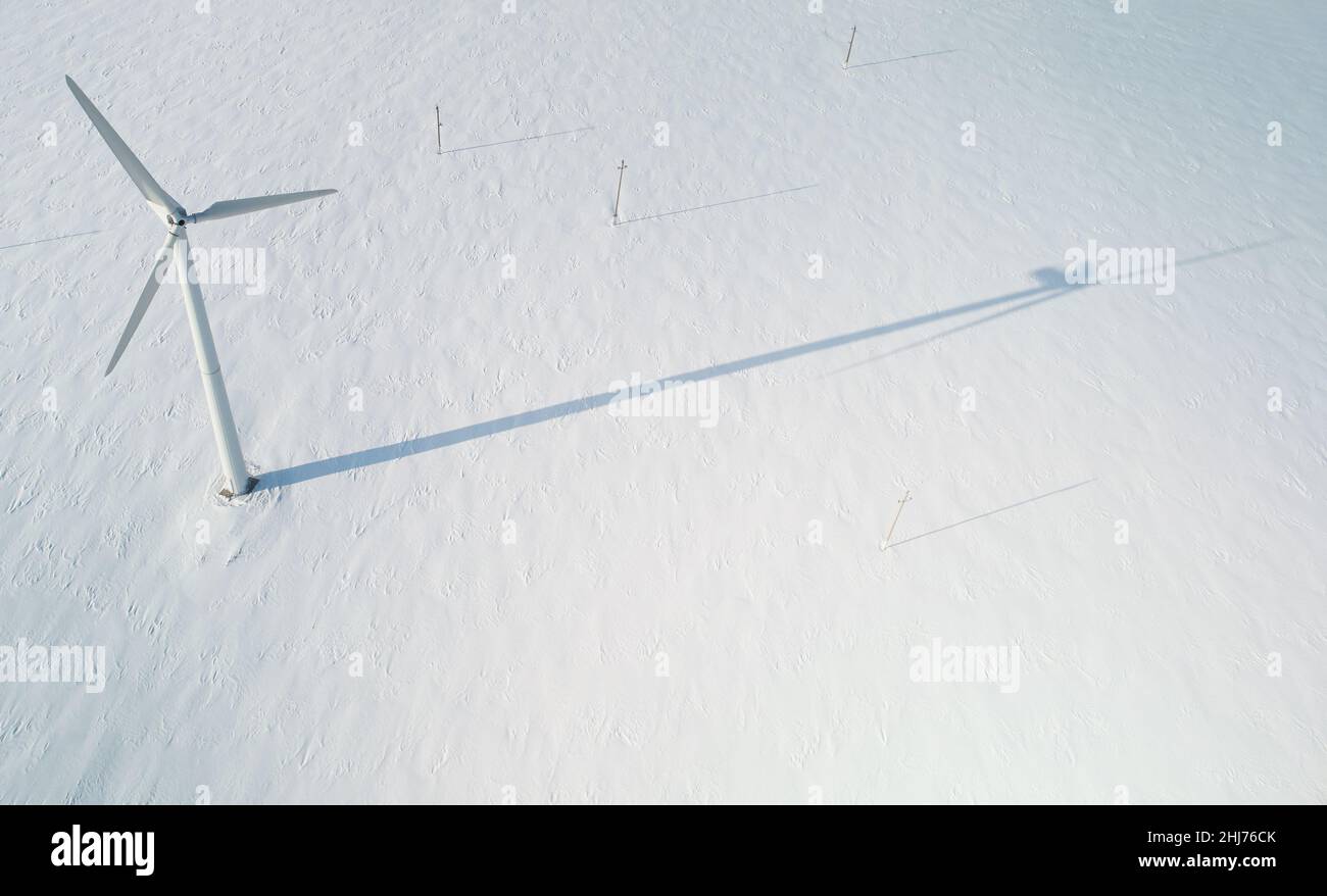 Wind electric generator mill on winter snow field background  aerial drone top view Stock Photo