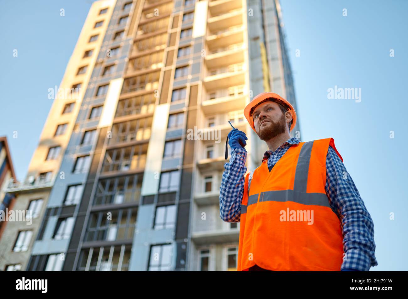 Builder worker using walkie-talkie on construction site Stock Photo