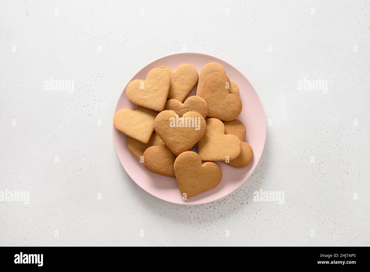 Valentine's Day heart shaped cookies on pink plate isolated on white background. View from above. Stock Photo