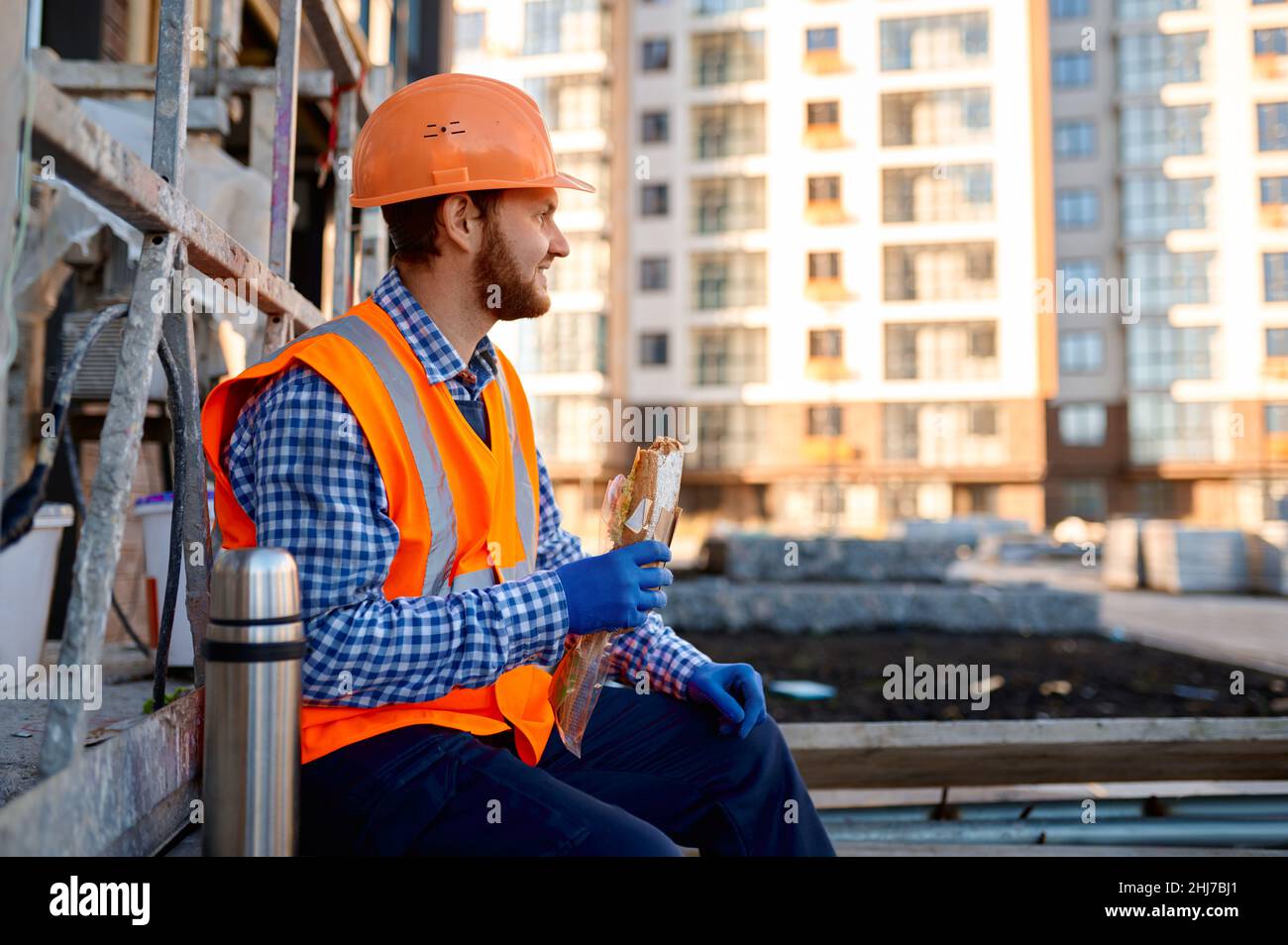 Construction worker eating sandwich during lunch break Stock Photo