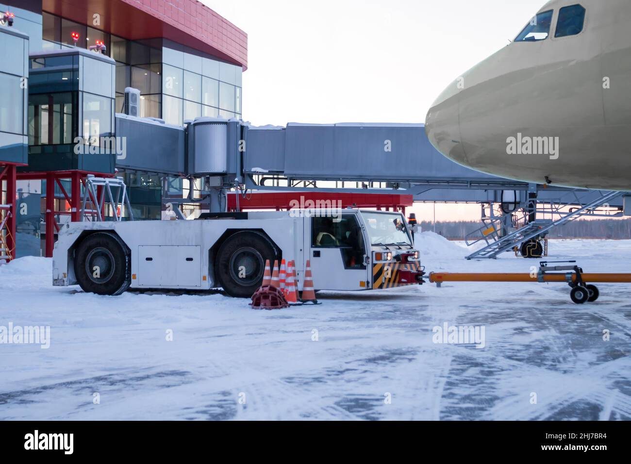 Tow truck pushes the airplane on the airport apron in winter Stock ...
