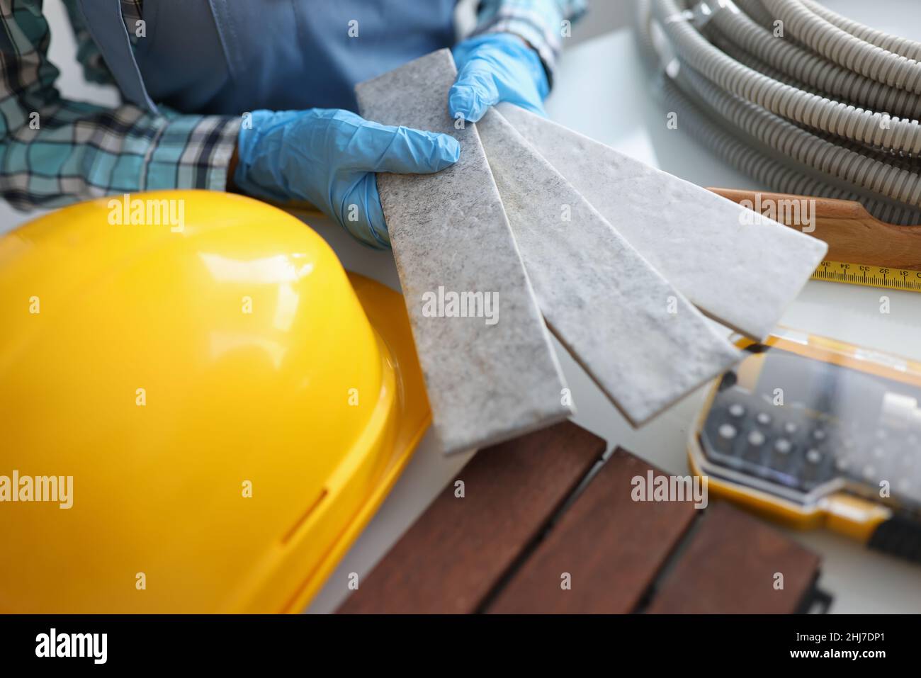 Builder holding gray tiles for bathroom in workshop closeup Stock Photo