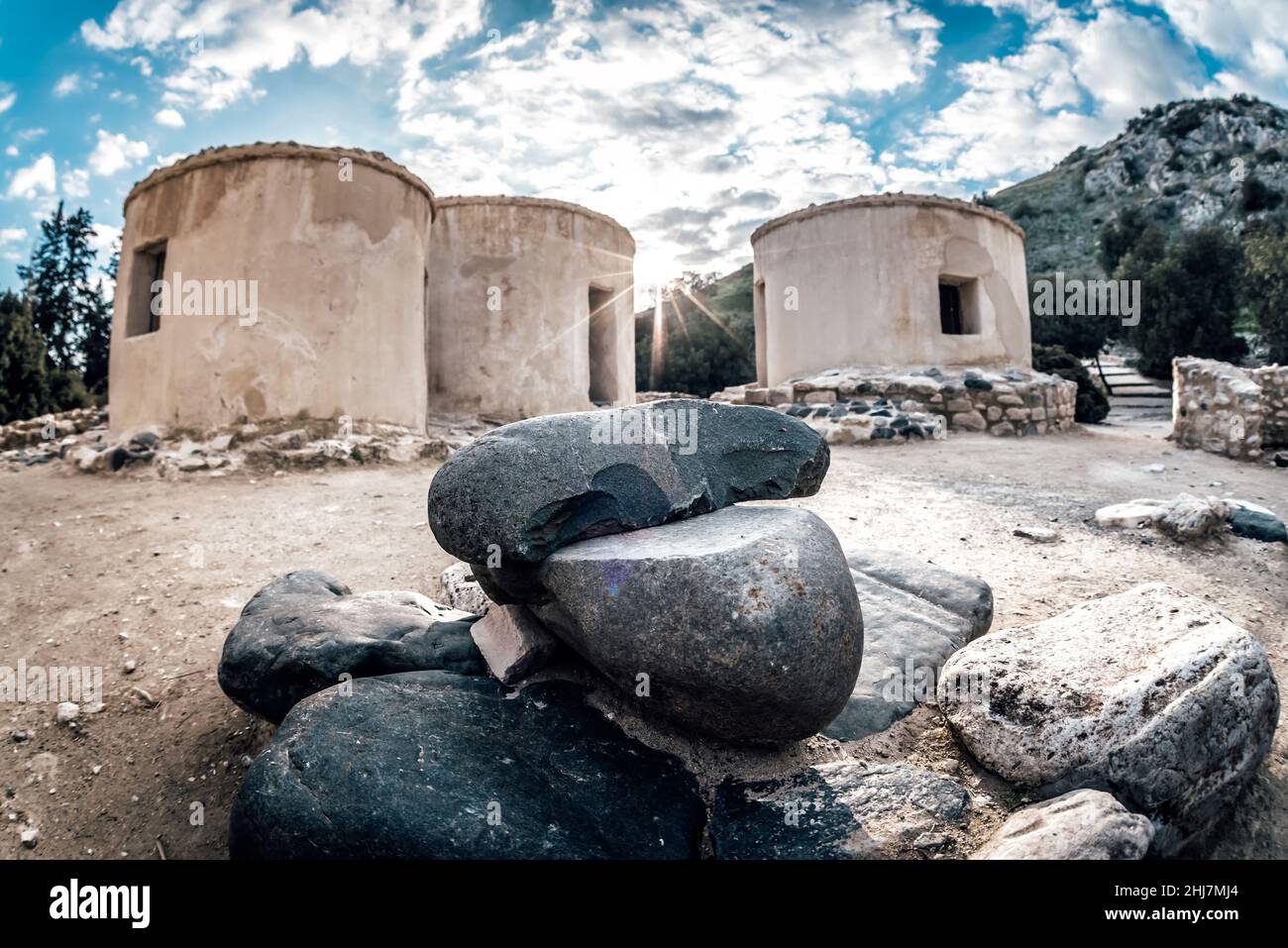 Reconstructed round houses of Neolithic era and stone tools at the archaeological site of Choirokitia settlement, Cyprus Stock Photo